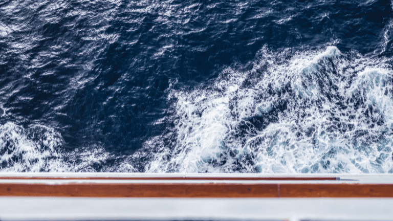 Churning ocean water beside a ship.