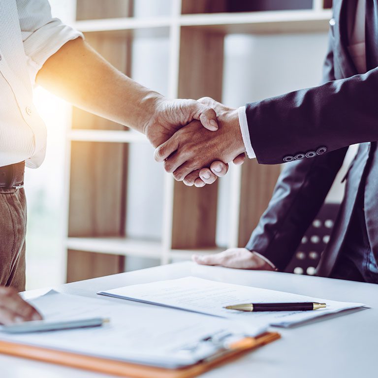 Middle age partner lawyers attorneys shaking hands after discussing a contract agreement done, Asian people.